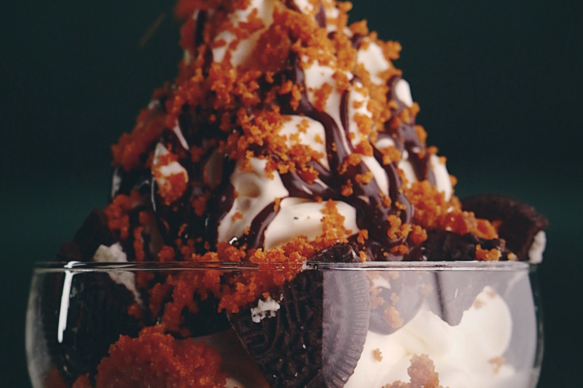 Soft Serve Deluxe med sjokoladesaus og smuler i stålskål